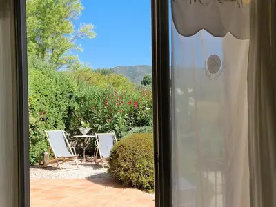a window view of a patio with chairs and a table at La Parenthèse in Lauris