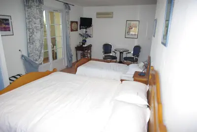 a bedroom with a white bed and two chairs at Le Mas de l'Amandier in Saint-Saturnin-lès-Avignon