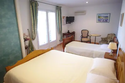 a hotel room with two beds and a window at Le Mas de l'Amandier in Saint-Saturnin-lès-Avignon