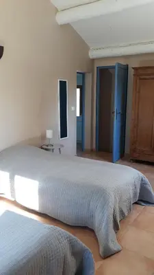 a bedroom with a large bed with a blue door at Le Mas des Vergers in Salon-de-Provence