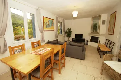 a living room with a wooden table and a couch at L'Oustalado in Maubec