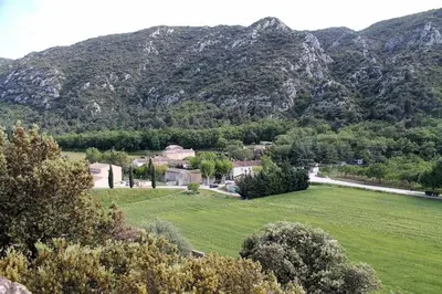 a house in a field with mountains in the background at L'Oustalado in Maubec