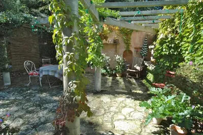 a garden with a table and some ivy at L'Oustalado in Maubec
