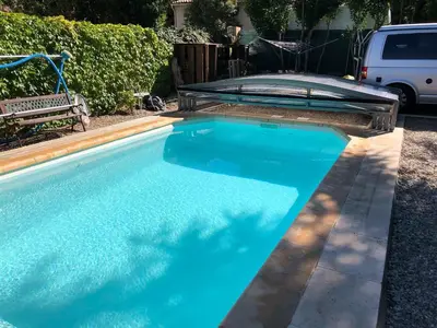a swimming pool with blue water in a yard at L'Oustalado in Maubec