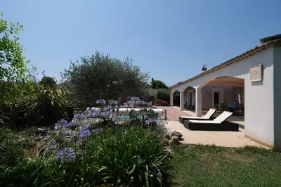 a garden with purple flowers next to a building at pleasant one-level villa with private pool in the thor village, close to l'isle sur la sorgue - 6 persons in Le Thor