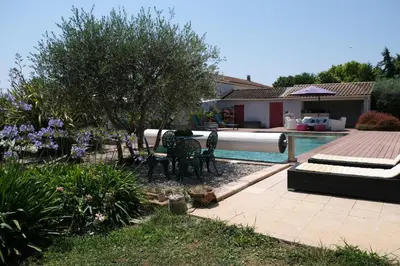 a backyard with a pool and a table and chairs at pleasant one-level villa with private pool in the thor village, close to l'isle sur la sorgue - 6 persons in Le Thor