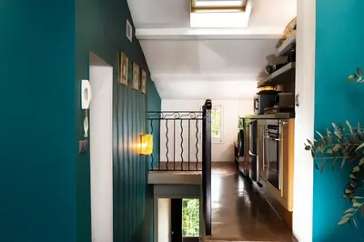 a hallway with a green wall and a stairway at Maison Dauphine in Aix-en-Provence