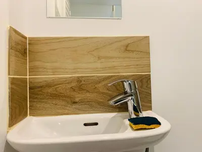 a sink in a bathroom with a wooden wall at Cassis Studio in Aix-en-Provence