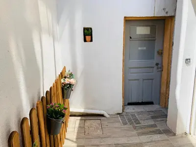 a hallway with a blue door and a bench with flowers at Montclar Studio in Aix-en-Provence