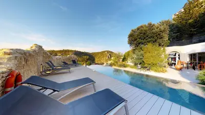 a swimming pool with lounge chairs next to a building at Metafort in Méthamis