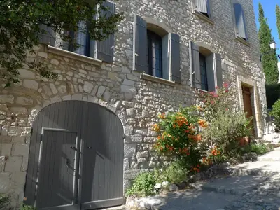 a stone house with a gate in front of it at Metafort in Méthamis