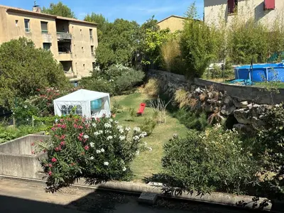 a garden with flowers and a white tent at Appartement 