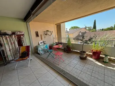 a balcony with a view of a patio with chairs at Appartement 