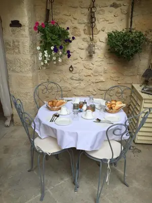 a table with a white tablecloth and chairs with food on it at Un Patio en Luberon in Ansouis