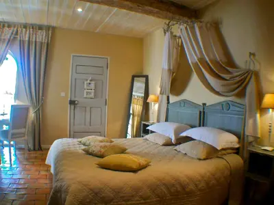 a bedroom with a large bed with pillows on it at Un Patio en Luberon in Ansouis