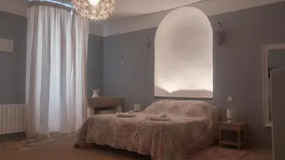a bedroom with a bed and a large window at Le Temps d'un Rêve in Mazan