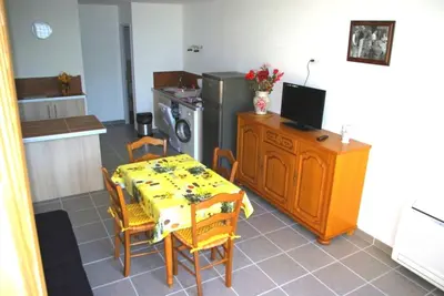 a kitchen with a dining table and a kitchen with a refrigerator at Gite le Mas de l'Amandier in Saint-Saturnin-lès-Avignon