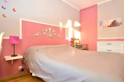 a bedroom with a white bed and pink walls at Villa envoûtante à Eyragues avec piscine in Eyragues