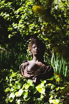 a statue of a woman sitting in the grass at Bastide Rose in Le Thor