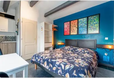 a bedroom with a bed and a blue wall at Chez Frédérique et Jean-Claude in Les Taillades