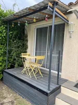 a yellow chair sitting on a porch of a house at Chez Frédérique et Jean-Claude in Les Taillades
