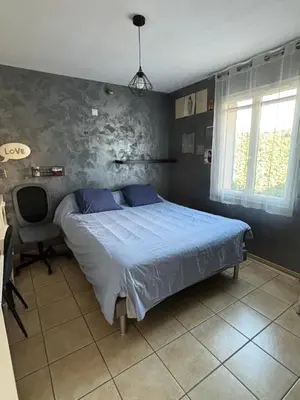 a bedroom with a bed and a desk and window at Chez Frédérique et Jean-Claude in Les Taillades