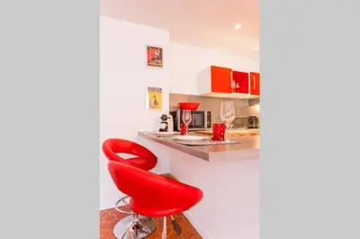a red chair in a kitchen with a counter at L'Entrecasteaux in Aix-en-Provence