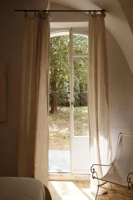 a living room with a white couch and a table at Le Galinier Lourmarin, a Beaumier Guesthouse in Lourmarin