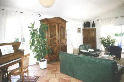 a living room with a green couch and a piano at Villa élégante à Céreste avec piscine privée et jacuzzi in Céreste