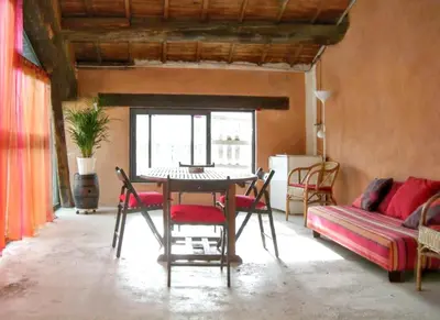 a living room with a table and chairs and a couch at Maison charmante avec terrasse et jardin à Noves in Noves