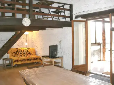 a living room with a couch and a clock at Maison charmante avec terrasse et jardin à Noves in Noves