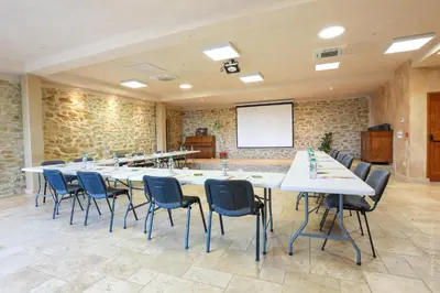 a conference room with a long table and chairs at Les Jardins de l'Abbaye in Simiane-la-Rotonde