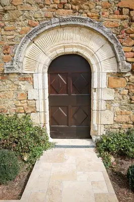 a large wooden garage door in a stone building at Les Jardins de l'Abbaye in Simiane-la-Rotonde
