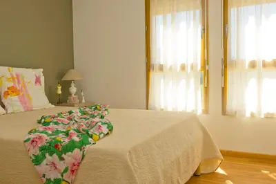 a bed with a white blanket with flowers on it at Résidence Goélia Le Domaine du Moulin Blanc in Gordes