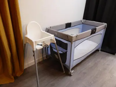 a baby crib and a chair in a room at Les Bernardines in Aix-en-Provence