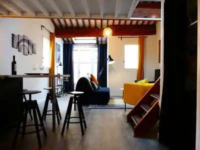 a living room with a bar and a yellow couch at Les Bernardines in Aix-en-Provence