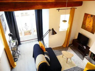 a living room with a couch and a tv at Les Bernardines in Aix-en-Provence