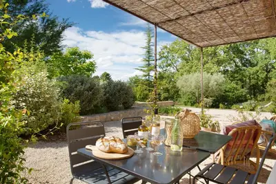 a black table with chairs in a garden at Domaine Les Petites Vaines in Goult