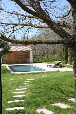 a swimming pool in a yard with a house at Le Fournil en Provence in Caseneuve