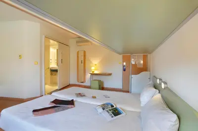 a bedroom with a large white bed in a room at First Inn Hotel in Apt