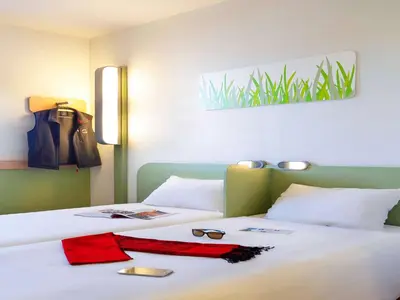 a bedroom with two beds with red ties and glasses on them at First Inn Hotel in Apt
