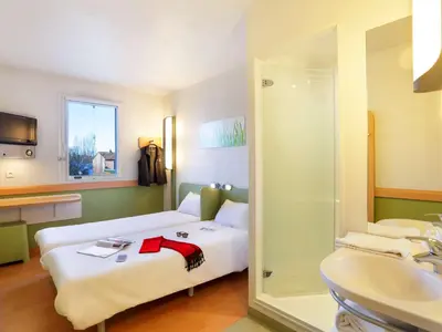 a hotel room with a bed and a sink at First Inn Hotel in Apt