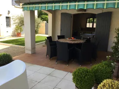 a patio with a table and chairs on it at authentic provencal mas with pool, in the countryside of the village of sénas, close to the luberon and the alpilles, sleeps 8. in Sénas