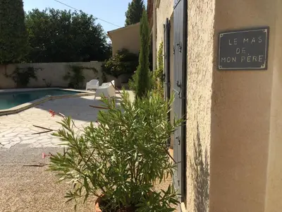 a sign on the side of a building with a plant at authentic provencal mas with pool, in the countryside of the village of sénas, close to the luberon and the alpilles, sleeps 8. in Sénas