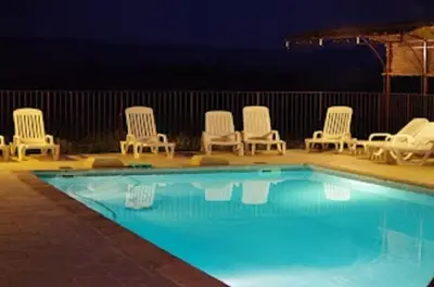 a group of chairs and a swimming pool at night at Chambres & Tables d'hôtes Moulin de Lavon in Gargas