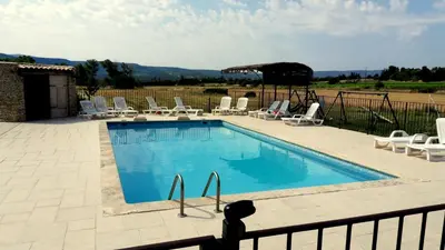 a swimming pool with a bunch of chairs around it at Chambres & Tables d'hôtes Moulin de Lavon in Gargas