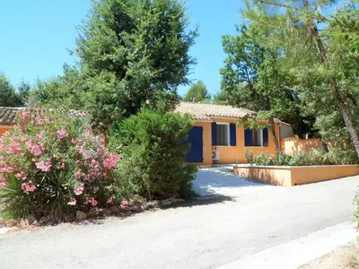 a house with a garden and flowers in front of it at Villa Célestine in Roussillon