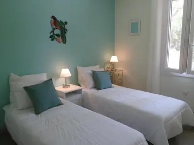 two beds in a small room with two lamps at Villa Célestine in Roussillon