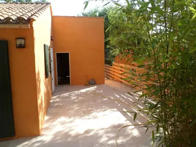 a courtyard of a house with an orange wall at Villa Célestine in Roussillon