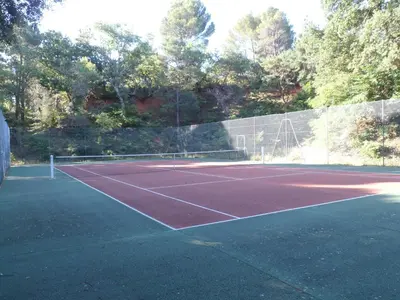 a tennis court with a net on it at Villa Célestine in Roussillon